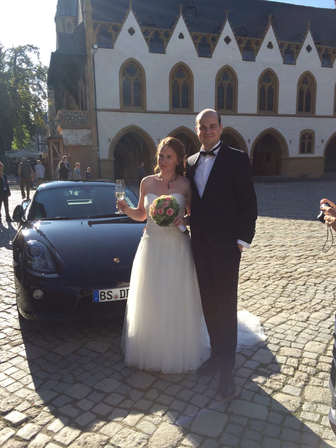 Katharina and Dorian Koch with their Porsche Cayman on their wedding day in Goslar, Germany