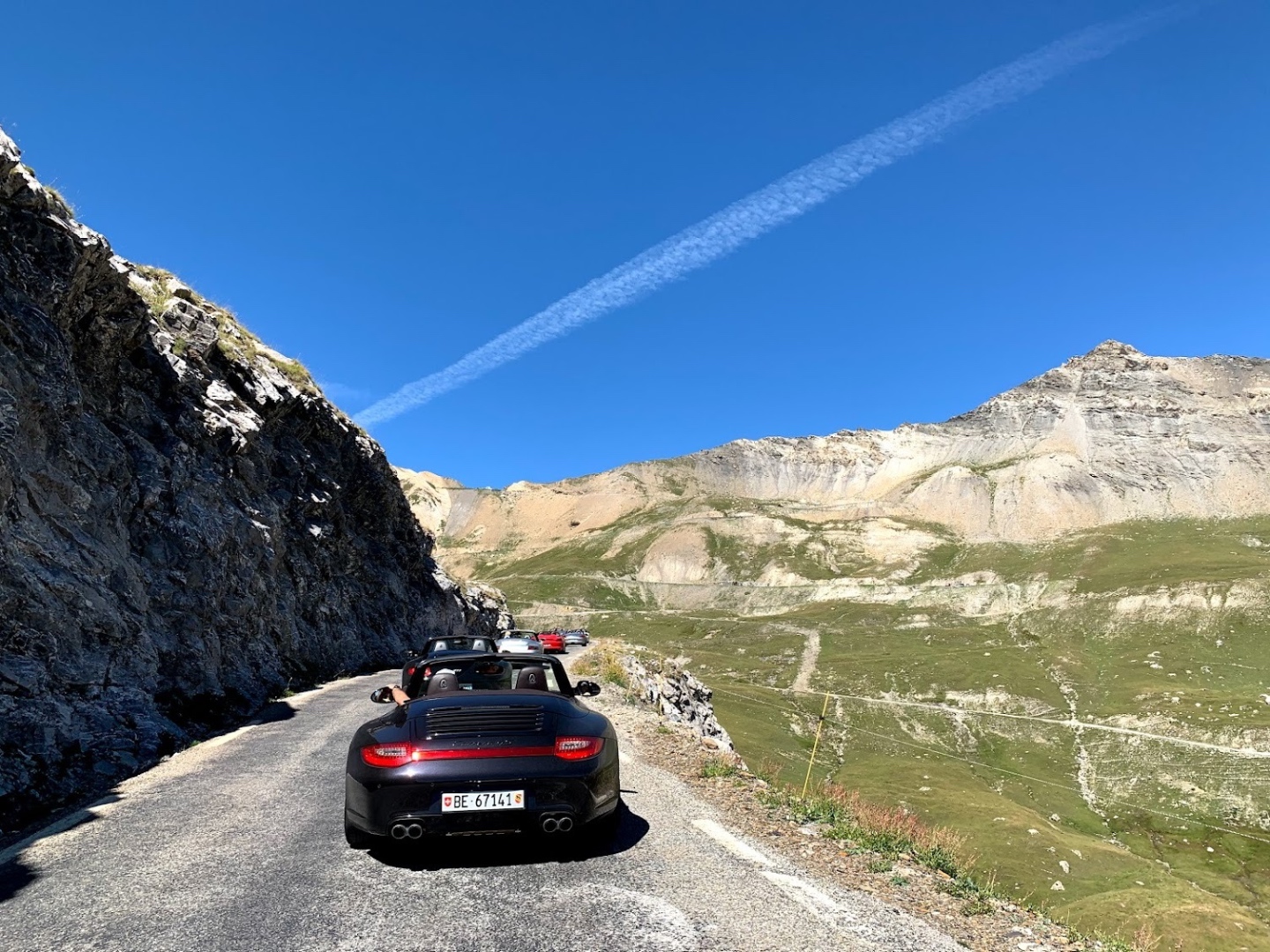 Black 911 cabrio on a narrow Alpine mountain pass
