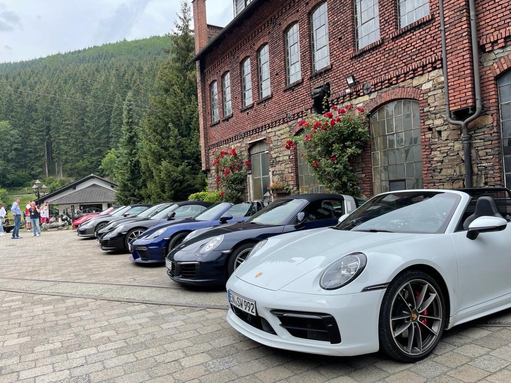 Line of 911s parked at a historic brick building in the German forest